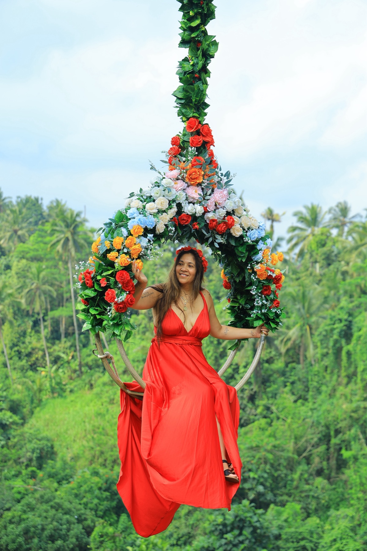 Leila in red dress on flower swing in Bali