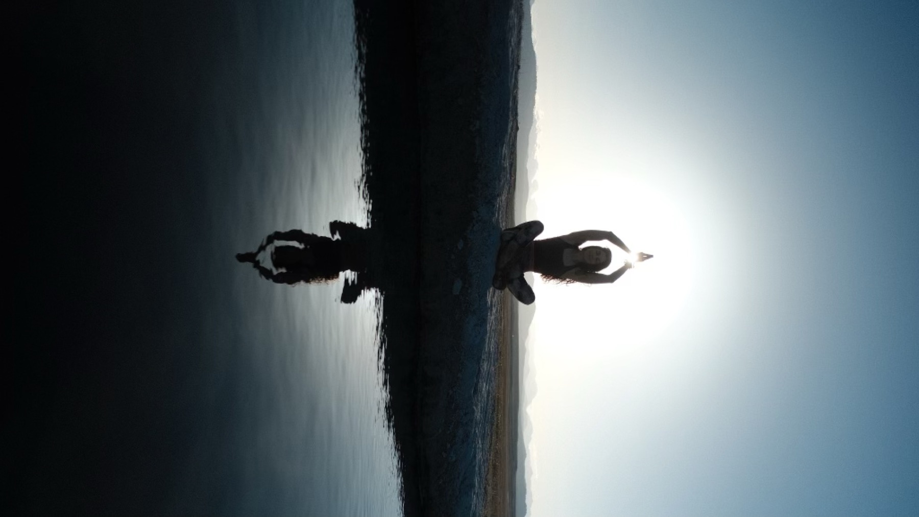 Yoga at sunrise reflected in still water